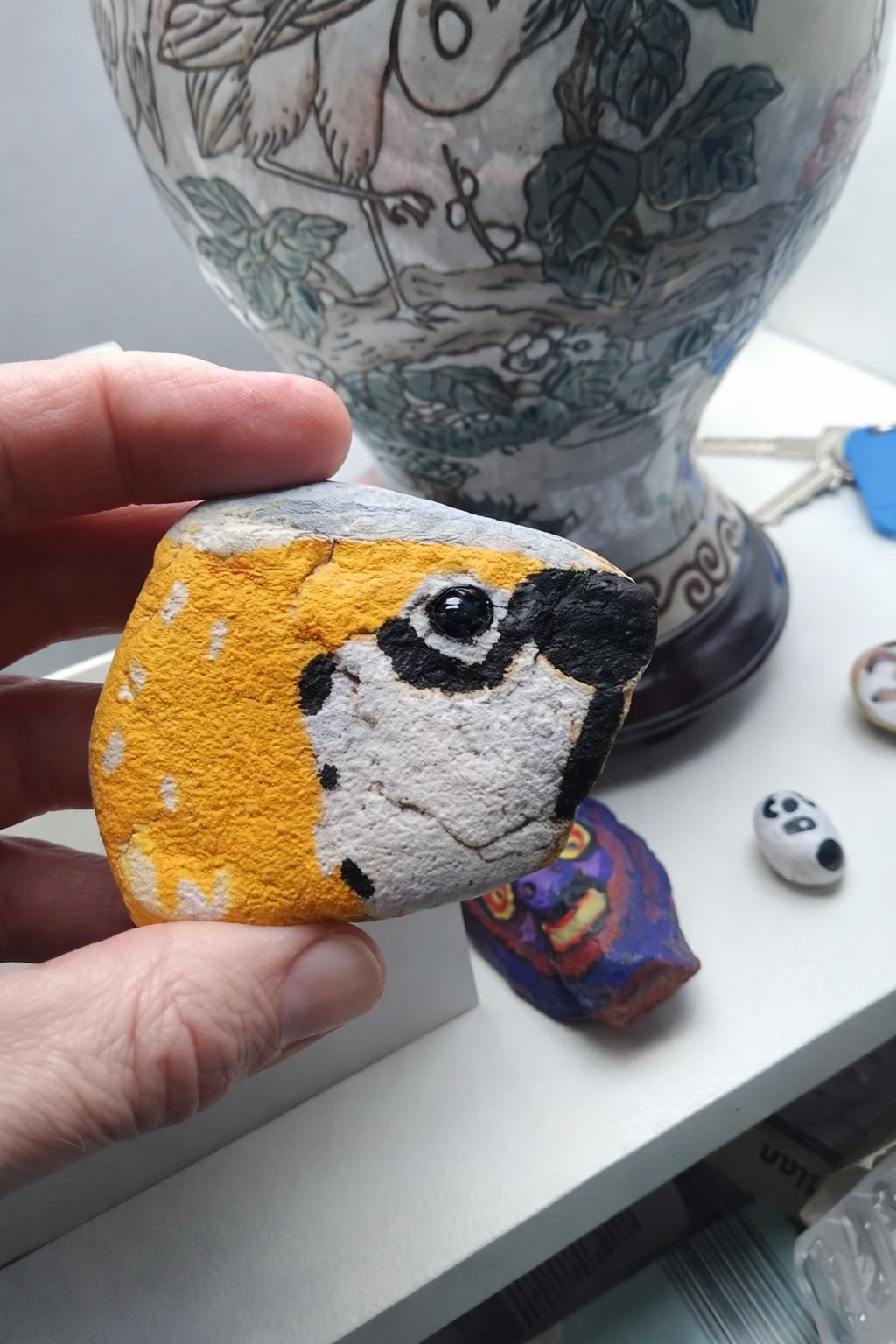 Wróbelek namalowany akrylem na kamieniu – profil z pomarańczową czapeczką